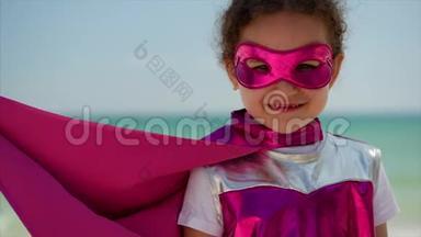 肖像可爱的小女孩在超级<strong>英雄</strong>服装，穿着粉红色斗篷和面具的<strong>英雄</strong>。 坐在飞机上